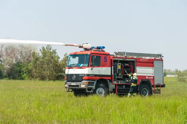 BORYSPIL, UKRAINE - MAY, 20, 2015: Fire-brigade on Fire Engine Mercedes using a water cannon during a training event at Boryspil International Airport, Kiev, Ukraine.