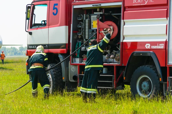 BORYSPIL, UKRAINE - MAY, 20, 2015: Firefighter lifted the Red hose after training put off the fire at Boryspil International Airport, Kiev, Ukraine.