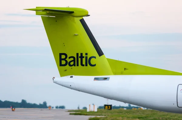 KIEV, UKRAINE - JULY 10, 2015: The tail of the aircraft Air Baltic propeller airplane taxis to teminal at International Borispol airport. Airbaltic is Latvian national airline