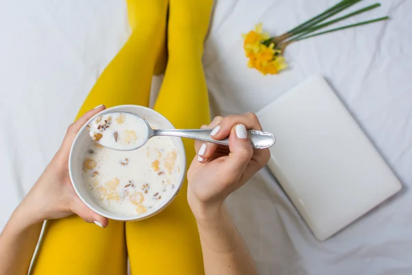 Girl eating cereals in bed