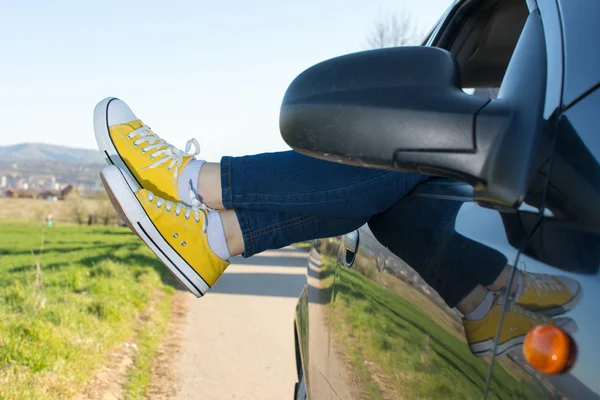 Woman legs out of the car window