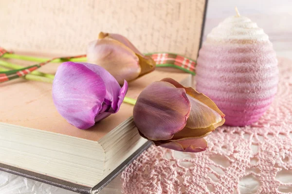 Purple tulips and a book