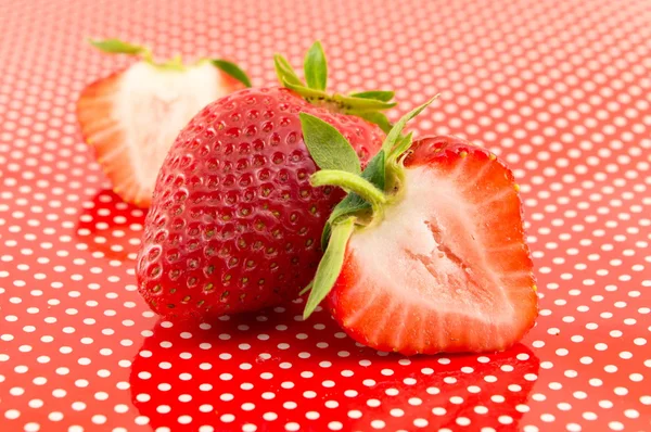 Fresh strawberries on a red dotted background