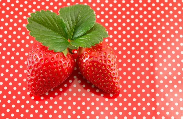 Fresh strawberries on a red dotted background