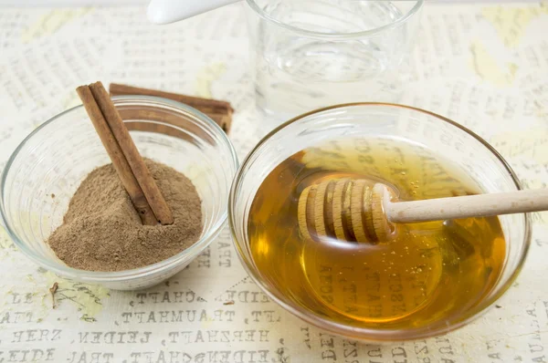 Honey and cinnamon in glass vessels on a table