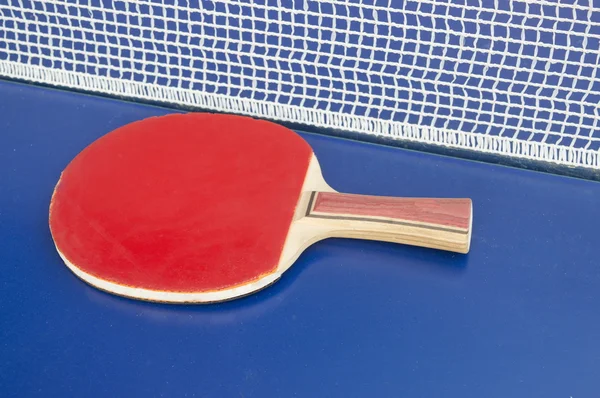 Table tennis paddle and net on a table