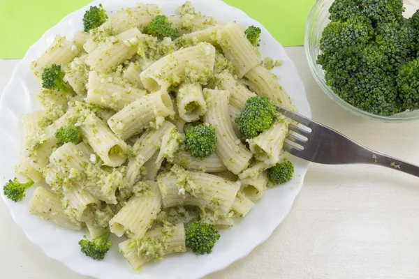 Pasta with broccoli served with cooked broccoli in a white bow o