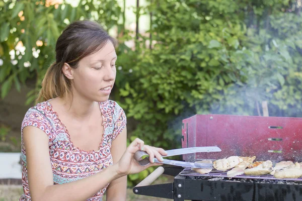Young woman preparing barbecue