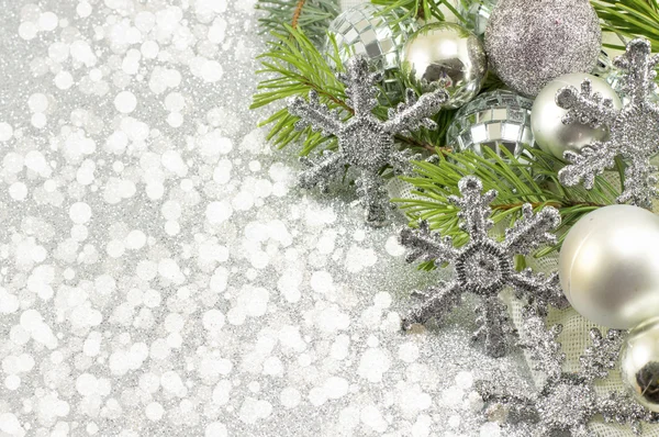 Silver colored Christmas ornaments and fir tree branch
