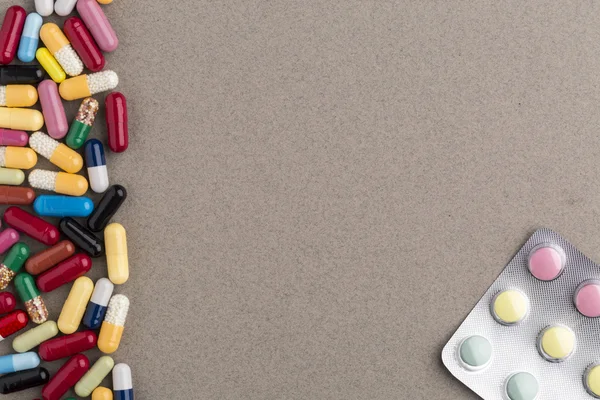 Various colorful capsules and pills on brown craft paper