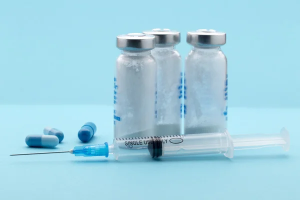 Healthcare and medicine,syringe, pills and medicine bottle on blue background