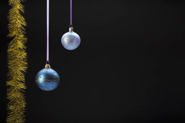 Hanging colorful christmas balls on black background