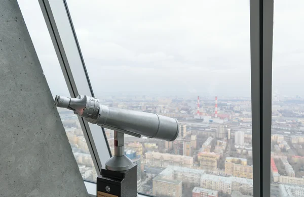 Binoculars on a viewing platform on the top floor of a skyscrape