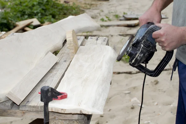 Joiner works with the surface of oak planks.