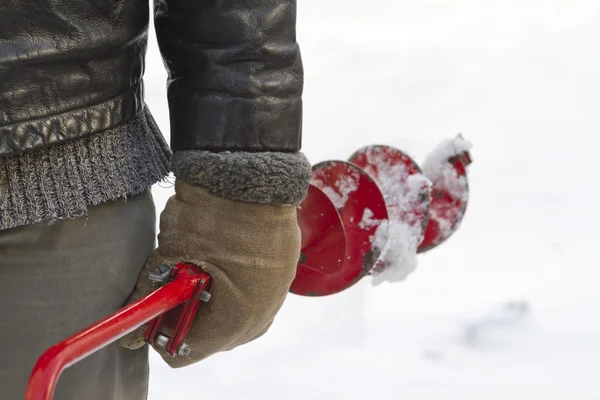 The hand of a fisherman in warm mittens.