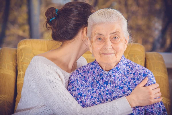 A young girl and an elderly grandmother. Girl hugging her grandm