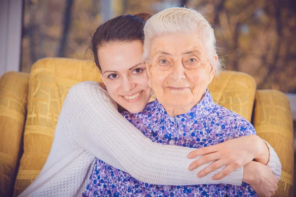 A young girl and an elderly grandmother. Girl hugging her grandm