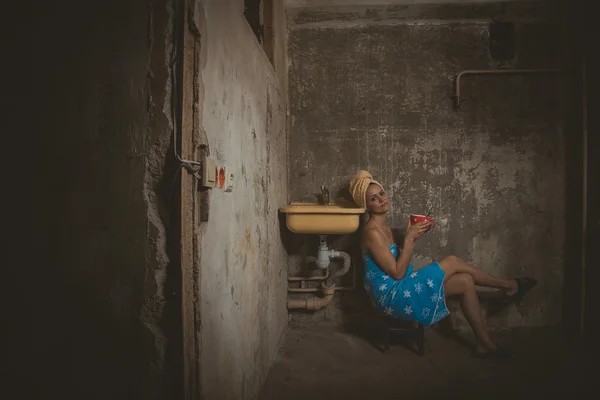 Cheap accommodation. Girl drinking tea in an old apartment