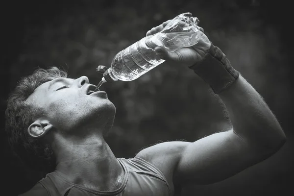 Man drinking water after running banks. Black and white photogra