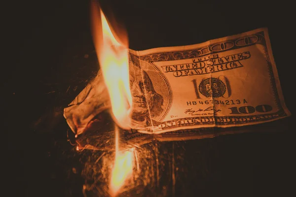 One hundred dollar bill on fire. Treatment with toning effect