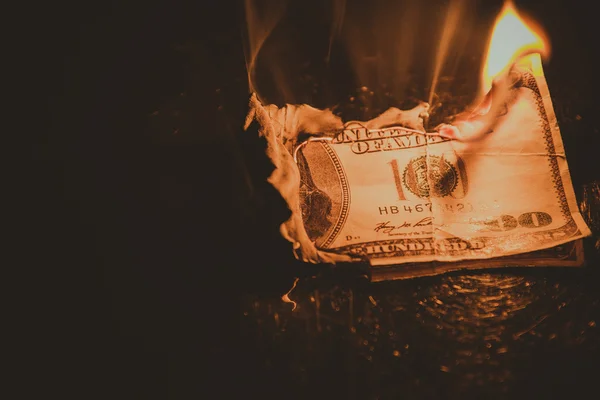 One hundred dollar bill on fire. Treatment with toning effect