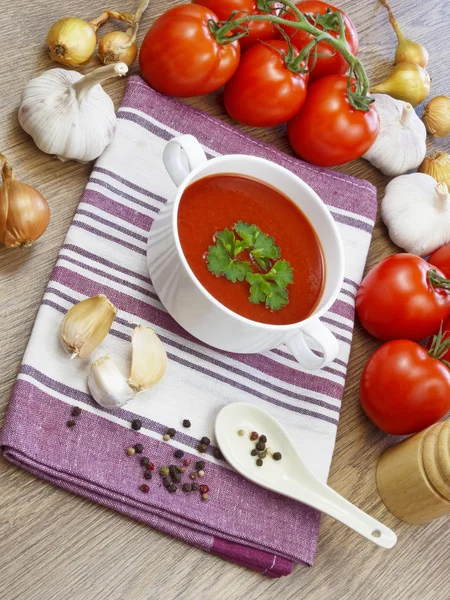Summer gazpacho soup with vegetables on wooden table