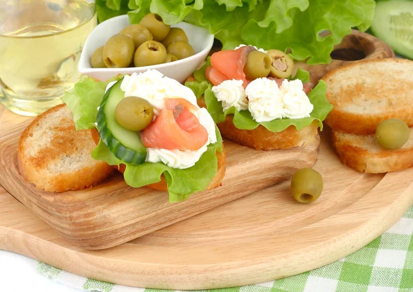 Salmon, lettuce and fresh cucumber sandwiches on a white background.