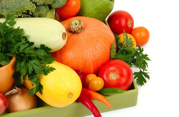 Fresh autumn vegetables in a green box on a white background.