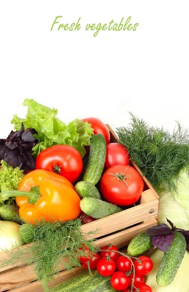 Fresh ripe vegetables in a wooden box on a white background with a place for the text.