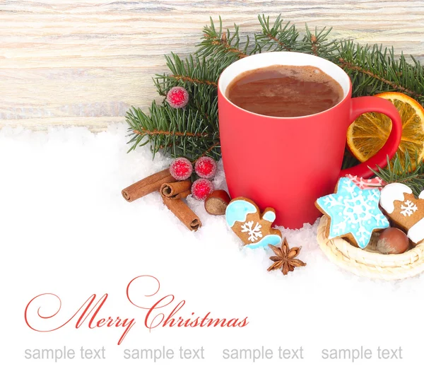 Red mug of hot chocolate, cinnamon and ginger cookies on snow on a white background. A Christmas background with a place for the text.