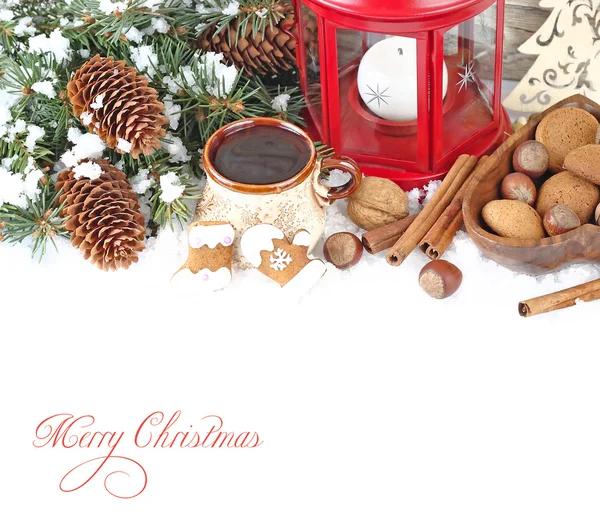 Christmas ginger cookies, cones, nuts and and a cup of tea on snow on a wooden background. A Christmas background with a place for the text.