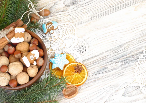 Christmas ginger cookies, nuts and dried oranges on a wooden background. A Christmas background with a place for the text.