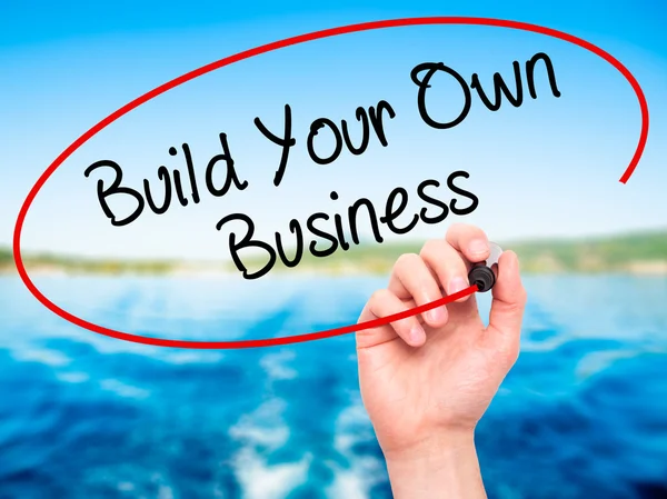 Man Hand writing Build Your Own Business with black marker on vi