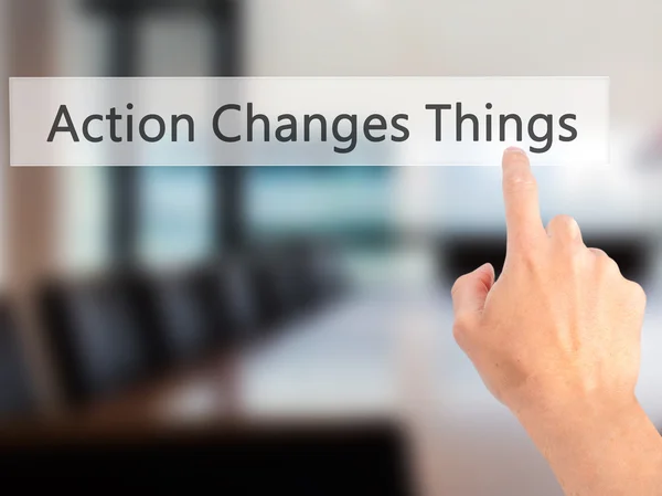 Action Changes Things - Hand pressing a button on blurred backgr