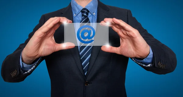 Email and contact symbols in front of businessman - Stock Image