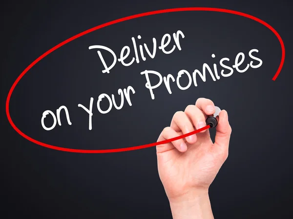 Man Hand writing Deliver on your Promises with black marker on v