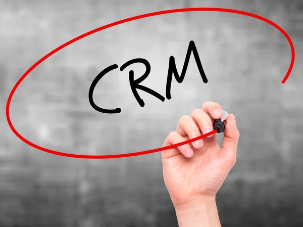 Man Hand writing CRM with black marker on visual screen