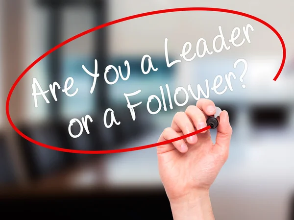 Man Hand writing Are You a Leader or a Follower? with black mark