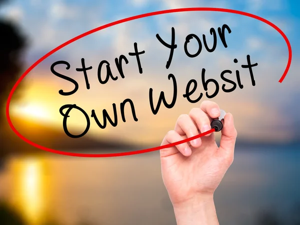 Man Hand writing Start Your Own Website with black marker on vis