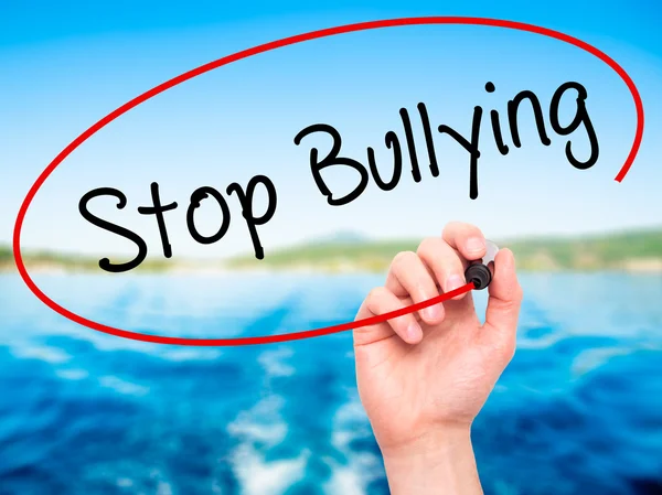 Man Hand writing Stop Bullying with black marker on visual scree