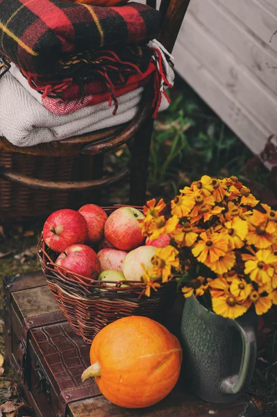 Fall at country house. Seasonal decorations with pumpkins, fresh apples and flowers. Autumn harvest at farm.