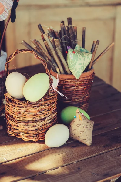 Easter eggs and decorations on wooden table in cozy country house, vintage toned