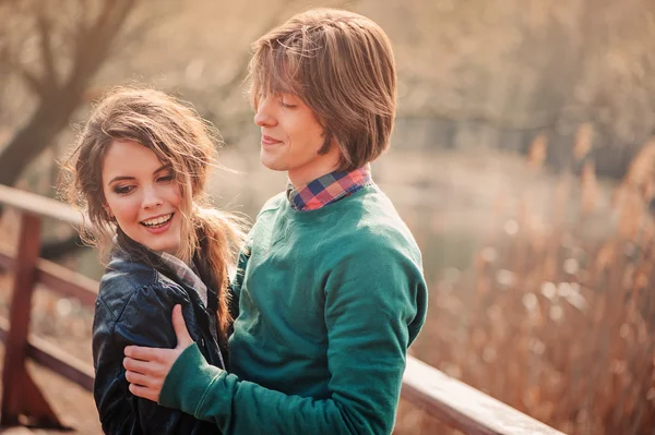 Young happy loving couple spending time together outdoor on spring country walk. Boyfriend and girlfriend hugs and laugh. Lifestyle capture.