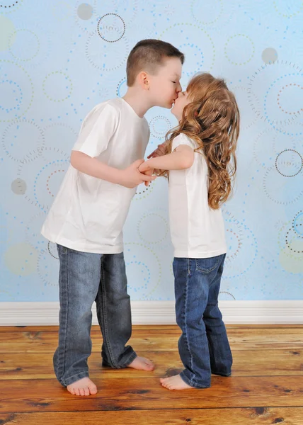 adorable young brother and sister sharing a kiss