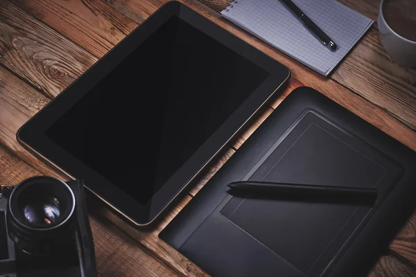 Tablet and graphics tablet on a wooden background