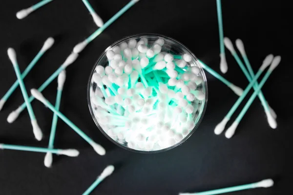 Cotton swabs in clear glass jar on black background