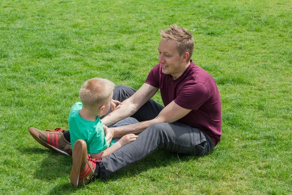 Father and son playing on the green grass