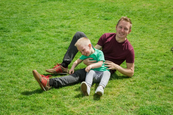 Father and son playing on the green grass