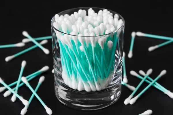 Cotton swabs in clear glass jar on black background