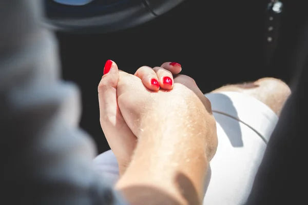 Loving couple holding hands in car